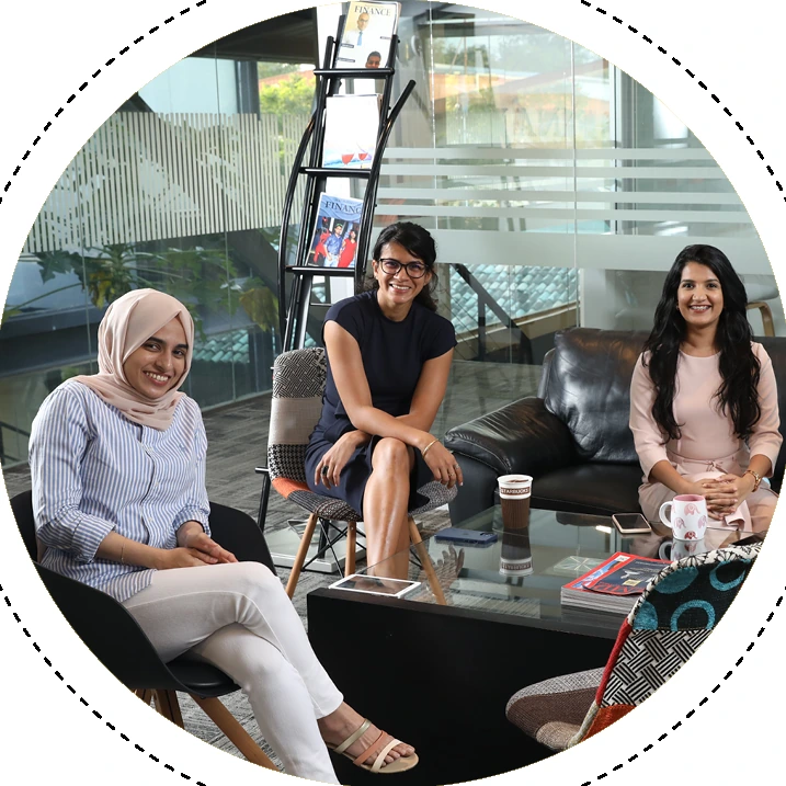 Three MAS women colleagues seated together on a sofa at a women's-network gathering